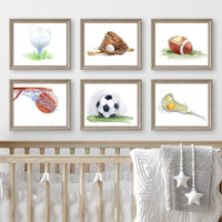 Thumbnail for Framed illustrations of sports equipment on a wall above a crib.