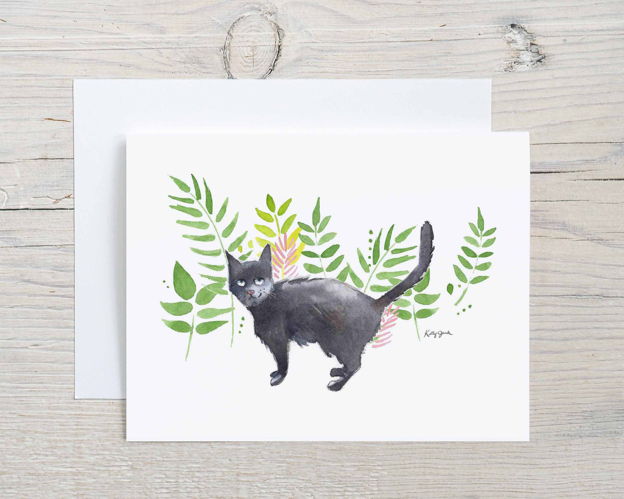 black cat with green leaves background
